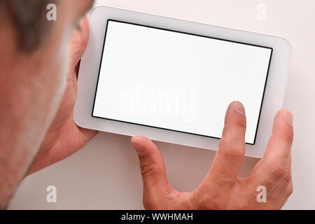 Man using white tablet with white screen on wood table close up. Horizontal composition. Top view Stock Photo