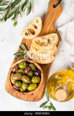 Olives, ciabatta and olive oil on white background. Stock Photo
