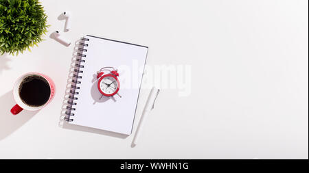 Alarm clock on notebook and coffee cup on white Stock Photo