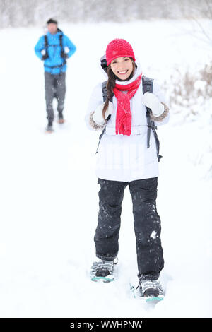 snowshoeing winter hiking. Active couple on snowshoes outdoors in snow walking in natural park in Canada, Quebec. Stock Photo