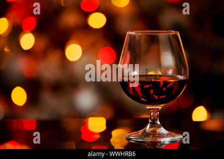 photo of cognac glass in front of bokeh background and glass table Stock Photo