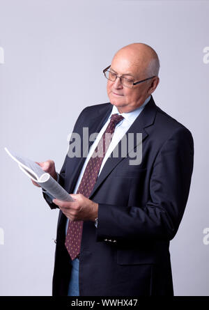 portrait of a successful senior man with book on gray background Stock Photo