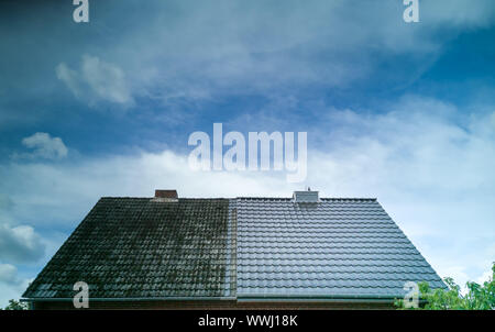 A half cleaned house roof shows the before and after effect of a roof ...