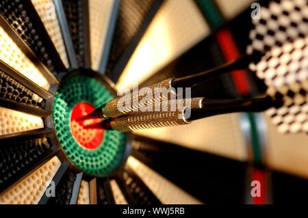 Three arrows in the centre of a dart board. Shallow depth of field Stock Photo