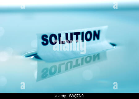Card floating on water surface with printed word: SOLUTION Stock Photo