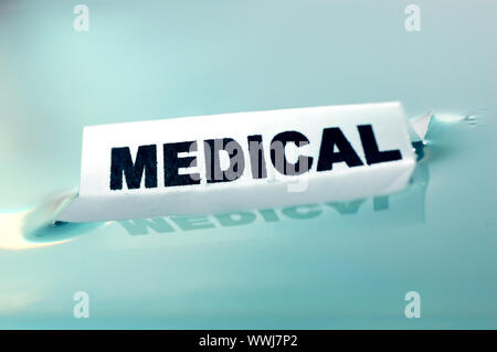 Card floating on water surface with printed word: MEDICAL Stock Photo