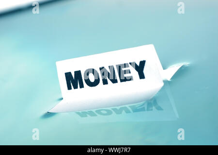 Card floating on water surface with printed word: MONEY Stock Photo