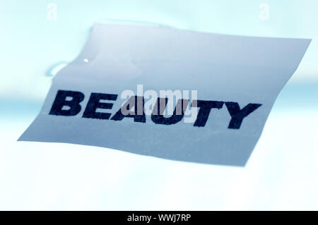 Card floating on water surface with printed word: BEAUTY Stock Photo