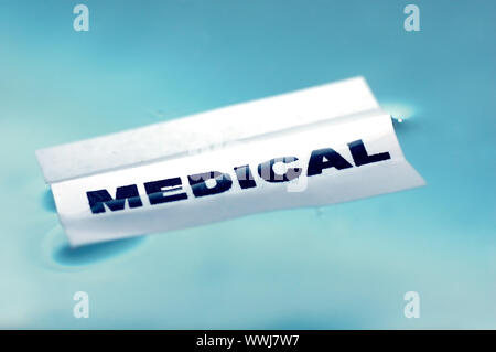 Card floating on water surface with printed word: MEDICAL Stock Photo