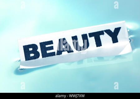 Card floating on water surface with printed word: BEAUTY Stock Photo