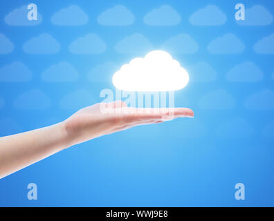 Woman hand share the cloud against blue background with clouds. Concept image on cloud computing theme with copy space. Stock Photo