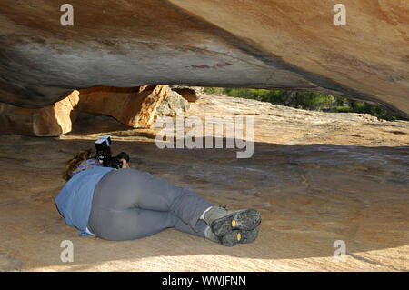 Visitors take pictures of prehistoric Bushman rock paintings Stock Photo