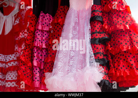 gipsy flamenco dancer costumes in a row pink and red colors with spots Stock Photo