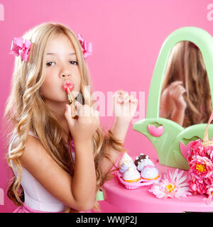 fashion little doll girl in pink vanity mirror with lipstick Stock Photo