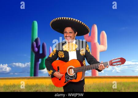 Mexican mariachi charro singing playing guitar in cactus background Mexico Stock Photo