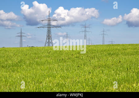 High voltage pylons on meadows Stock Photo