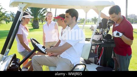 Golf course young team people group buggy green grass field Stock Photo
