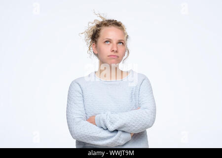 Beautiful pensive woman in studio looking up trying to make a right decision. Studio shot Stock Photo