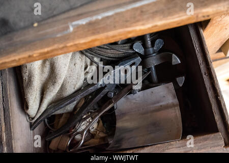 Scissors, vise, pliers, burlap in an old box. The chest of an old chest of drawers Stock Photo