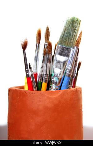Artist used brushes clay pot isolated on white Stock Photo