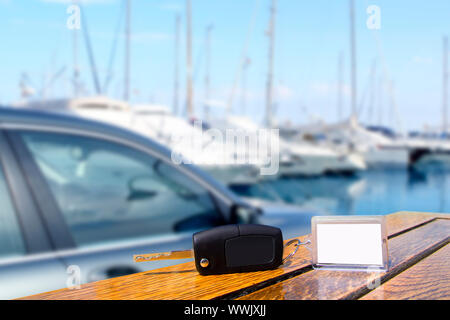 Car rental keys on wood table with blank paper in vacation boats Mediterranean marina Stock Photo