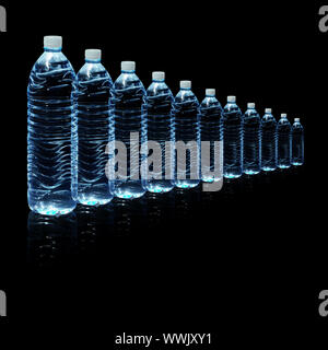 Several bottles of drinking water isolated on a black background Stock Photo