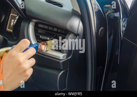 clean the car's air conditioner in the passenger room by using a dust brush to prevent dirt in the car. Stock Photo