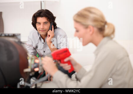 female technician working while the client is talking on the phone Stock Photo