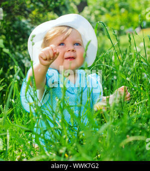 Clouse-up portrait pretty little girl sitting in the grass in the park Stock Photo