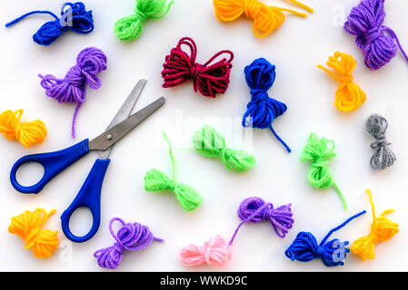 Knitting threads and scissors. Multi-colored bandaged threads for needlework. Materials to do the work at home. Making clothes. Stock Photo