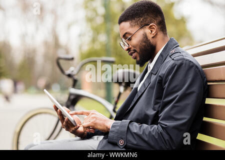 Young freelancer using digital tablet in park Stock Photo
