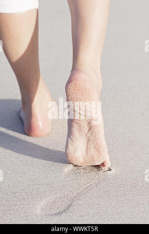 feet walking barefoot in the sand on the beach Stock Photo