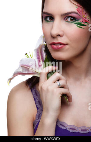 portrait of beautiful brunette with eye-zone body art posing with tiger lily Stock Photo