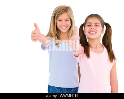 Two girl friends giving thumbs up smiling Stock Photo