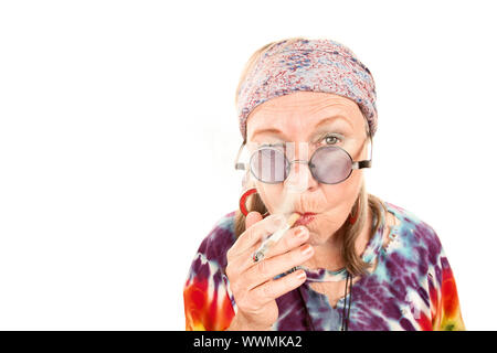 Senior hippie lady in tie dye with cigarette Stock Photo