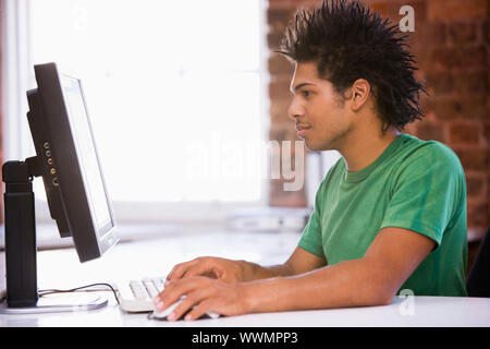 Businessman in office typing on computer Stock Photo