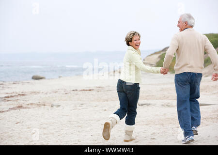 Couple at the beach holding hands and smiling Stock Photo