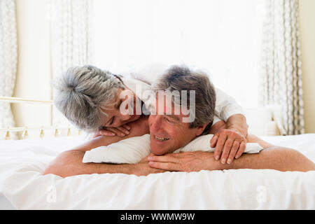 Couple relaxing in bedroom and smiling Couple relaxing in bedroom and smiling