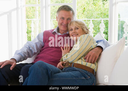 Couple in living room smiling Stock Photo