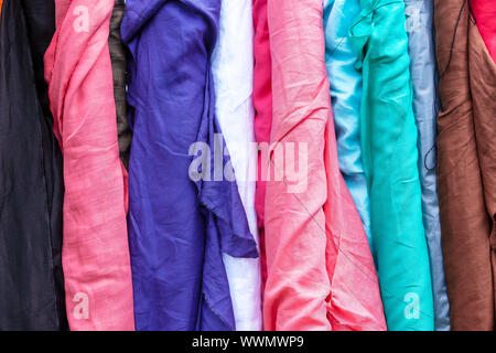 Bolts of different colour linen fabric on display. Stock Photo
