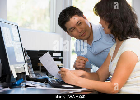 Couple in home office with computer and paperwork Stock Photo