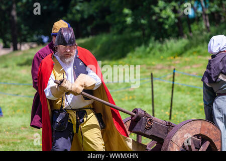 Demonstration of firing medieval  cannon by participants in costume at The Medieval Fayre in Tatton Park, Cheshire, UK. Stock Photo