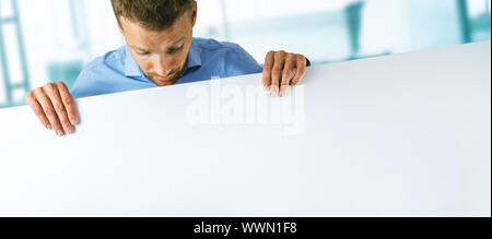 young man holding blank white banner with copy space Stock Photo