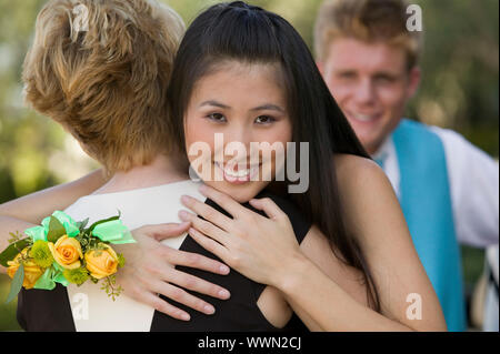 Teenage Girl Hugging Friend at Dance Stock Photo