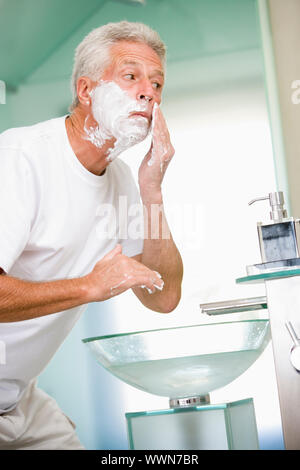 Man in bathroom shaving Stock Photo