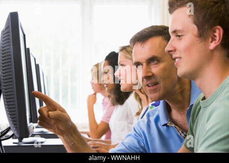 Teacher assisting college student in a computer lab Stock Photo - Alamy