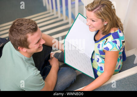 Male and female college students sitting on stairs Stock Photo