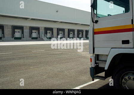 The loading area of a industrial warehouse with several loading bays and a truck. Stock Photo