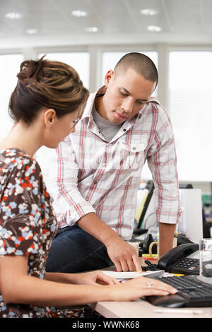 Businessman Assisting Co-Worker Stock Photo