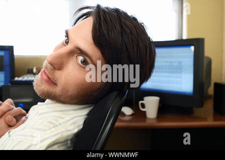 Man on Computer Looking Back Stock Photo
